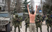 Протестующий местный житель пытается не допустить эскалации конфликта в Крыму, стоя перед военными без опознавательных знаков с российскими номерами на бронетехнике.