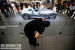 Рабочий полирует ограждение на стенде BMW.