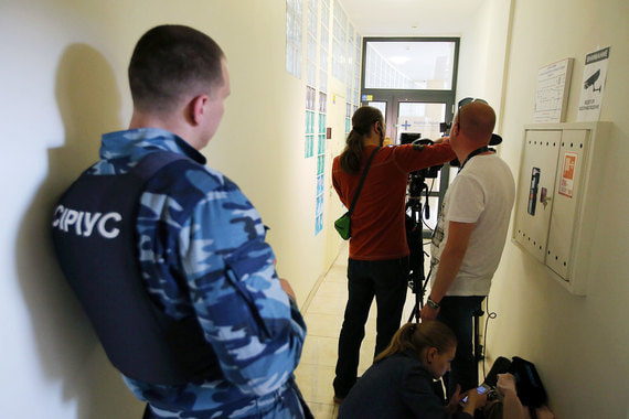 Охранник предприятия «Сириус» и журналисты у офиса «РИА Новости Украина» в Киеве, где СБУ проводит обыски