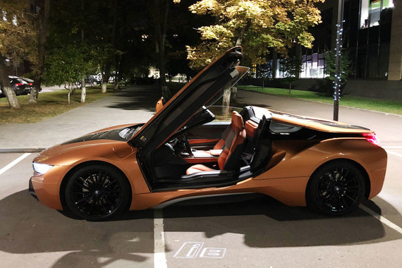 Войти в BMW i8 Roadster непросто: двери открываются вверх «крыльями бабочки», сиденье расположено близко к земле, а широкий порог – относительно высоко