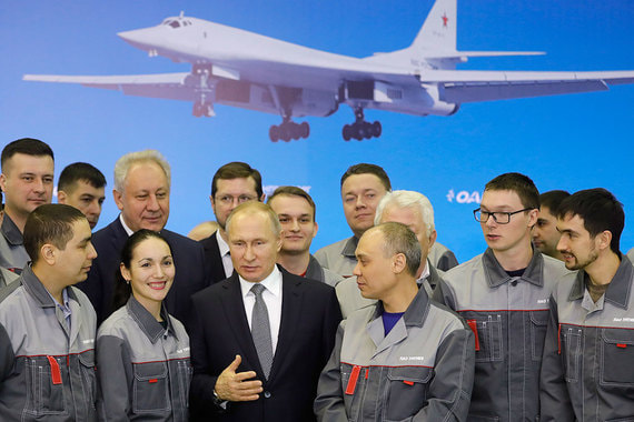 Президент Владимир Путин (в центре) во время беседы с рабочими завода
и пилотами самолета ТУ-160-М